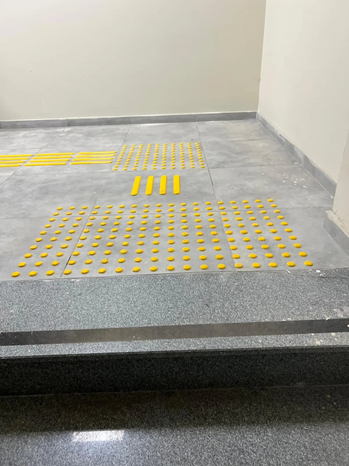 Granit basamaklar öncesinde sarı PVC uyarı butonları ve kılavuz çubuklar